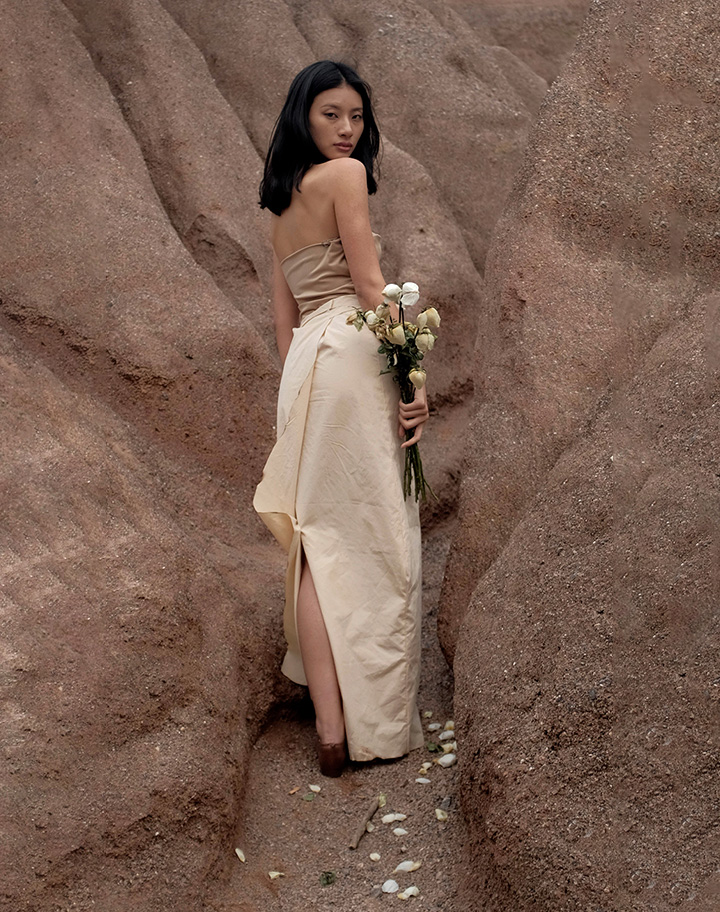 The drapery on the back of the skirt echos the detail on the elastic sleeveless top. The softness and stiffness between the top and bottom are tied together by the tie at the waist. The skirt has burnt edges.