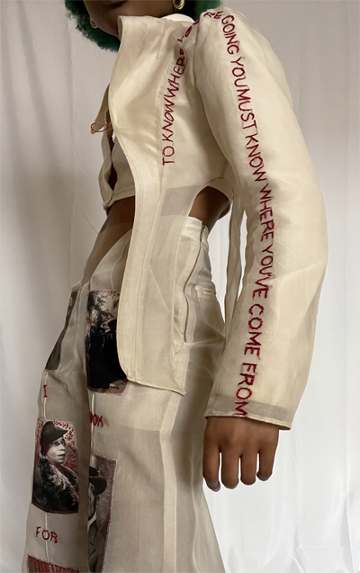 Side profile of beige chiffon blazer with hand embroidery stating "To know where you're going you must know where you've come from." 
