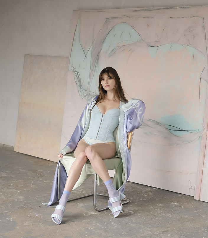 The inspiration for this collection started off with a series of paintings that the designer’s aunt, Wendy Jackal, created in New York City in the late 1970s. It was designed in conversation with these works as well as the time and place in which they were made. It features a hand-painted silk charmeuse robe and a corded bustier with deco hardware.