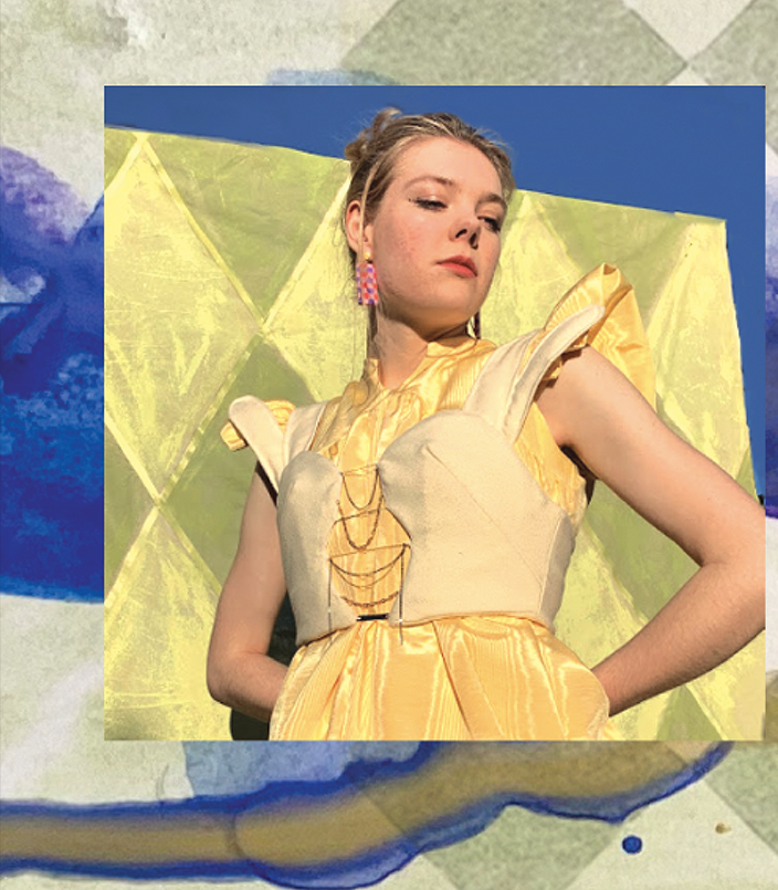 Close-up of rabbit bustier and daffodil dress. Rabbit bustier is composed of two white woolen rabbits with inside profile facing each other, connected by jewelry chain detailing down the front. Daffodil dress is bright yellow silk, with short, puffy sleeves. 