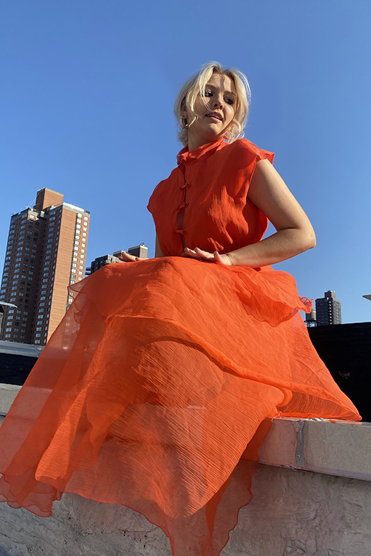 Model is wearing the same set and is crouched on the roof with a three-quarter angle.