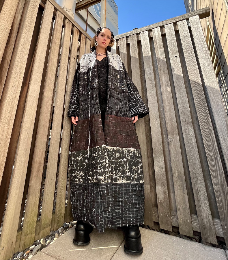 Front view of "bruise" oversized sustainably filled puffer coat, made of handcrafted fabric manipulations. Colors: White, black, grey, purple, cream