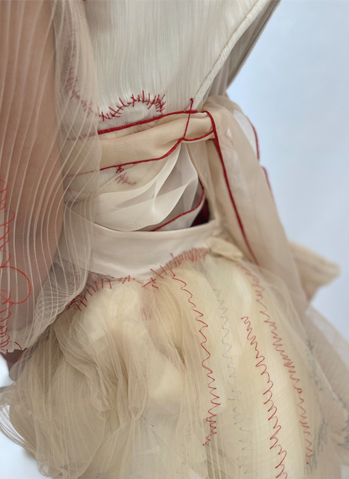 The back view of the skirt, delicately stitched in a zigzag pattern in different shades of red and blue thread.