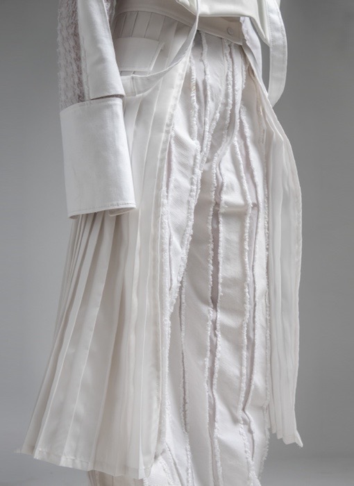 The pleated belt and the abstract striped pants are attached by the snaps on the waistbands.