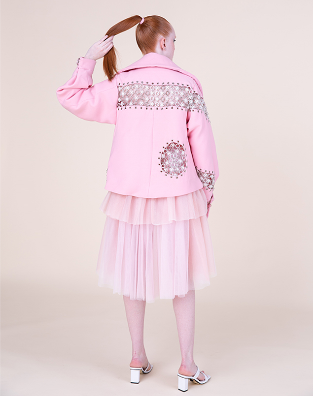 Model is shown wearing the jacket and dress, full body from the back.