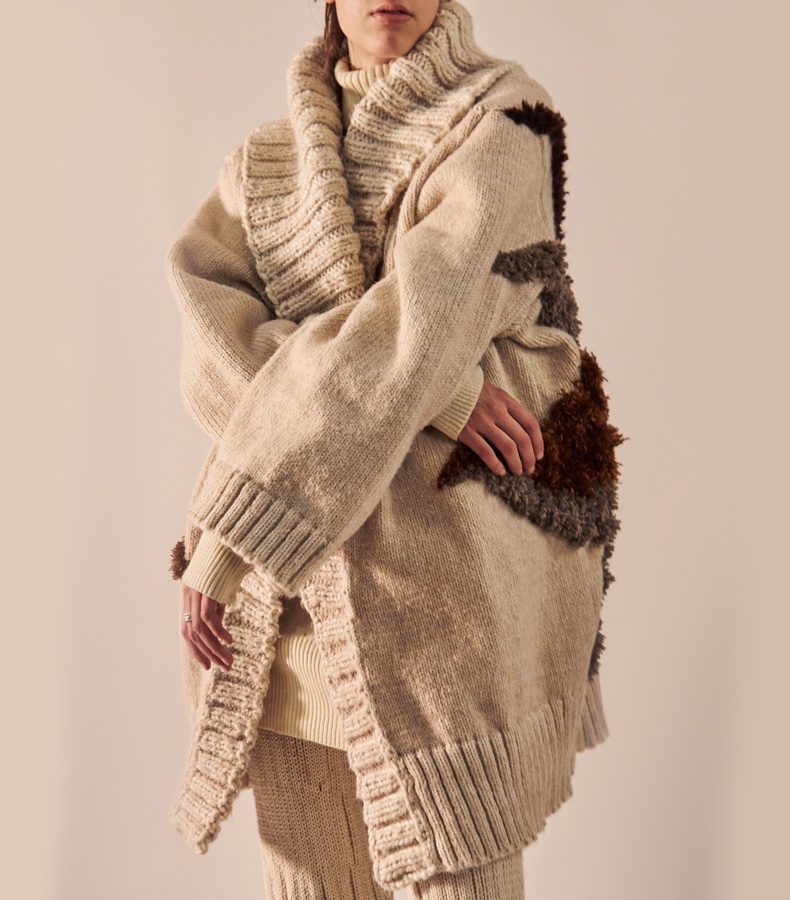 Close-up image of an oversized ivory cardigan with a chunky shawl collar