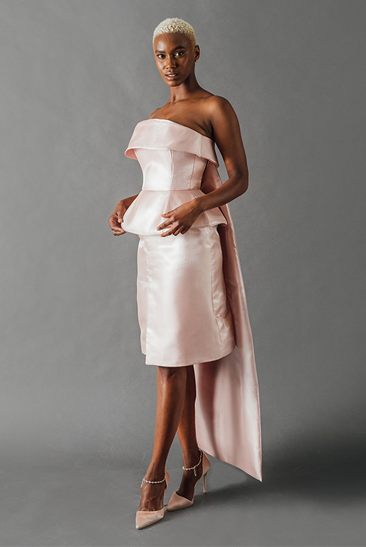 A full-length shot reveals a full-length cape at the back of the dress that adds drama to the structured dress.