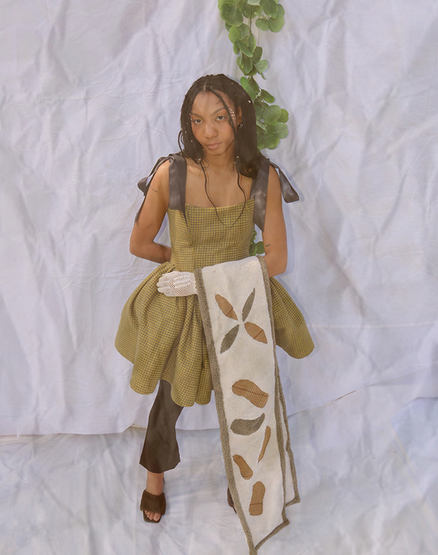 Image 5 is shot from above with a white background, showing the model in the dress and holding the shawl on one arm. The shawl covers one leg, on the other there is the flared pant and the furry heeled sandal.