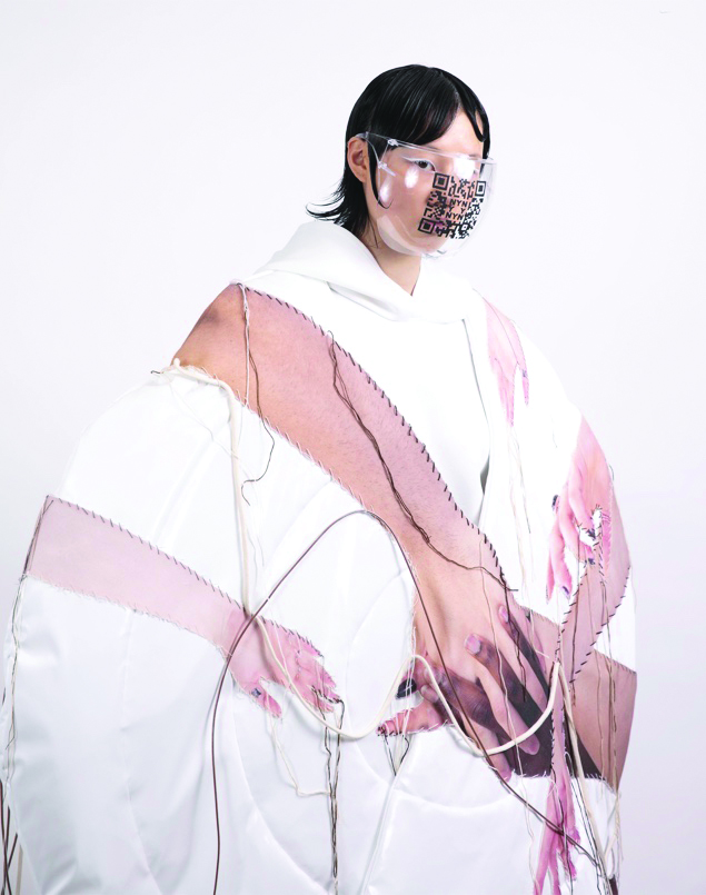 Puffer outer piece with embroidered photographed hands, styled with hoodie bodysuit and paired with headpiece 
