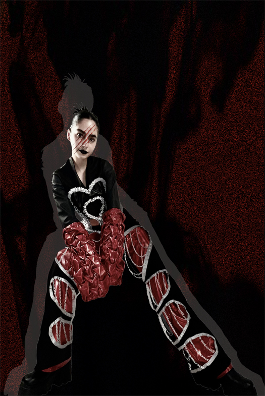 This image shows the model posing for a full shot of the look. The detailing, like the chains on the pants and the boning of the top, are very visible.