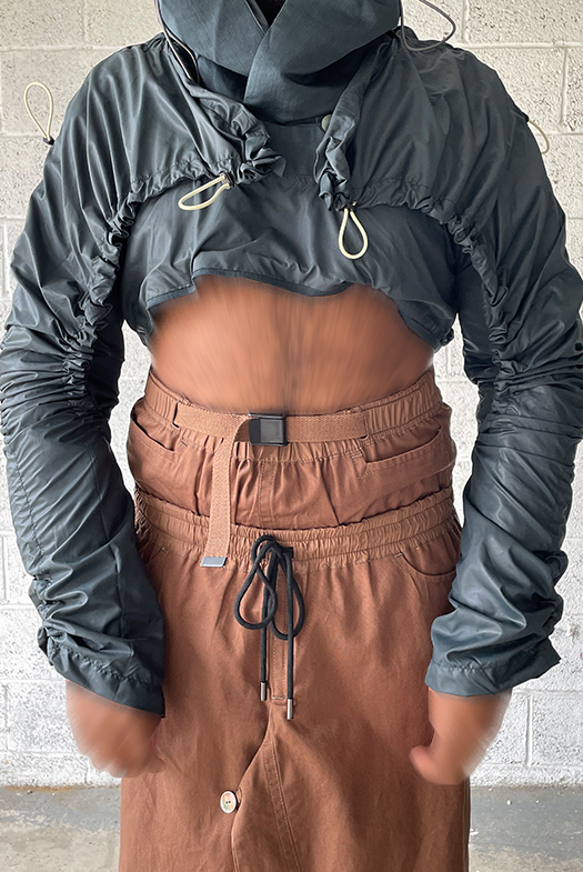 Detachable inner yoke. Nylon waistband, encased elastic with buckle. Detailed close-up of front look.