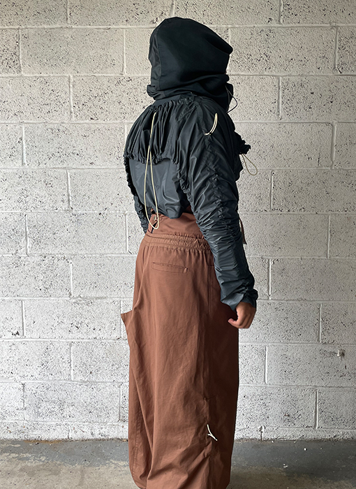 Welt pocket. Lower side seam. Draw cording detail. Back view 3/4 pose.