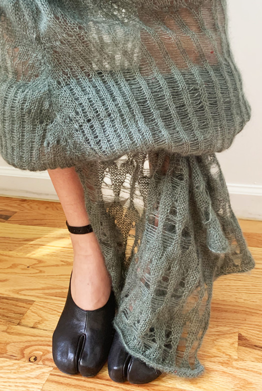 Close-up of drapery at bottom of the last skirt. Drapery falls elegantly in full folds, featuring alternating diamond shapes made by dropped stitches. 