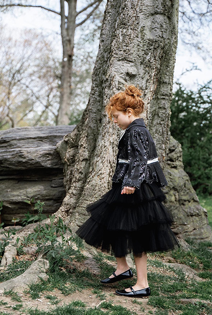 Tulle skirt was created by three layers of two different tulles. A side view photo of a little girl, and the background is the nature view.
